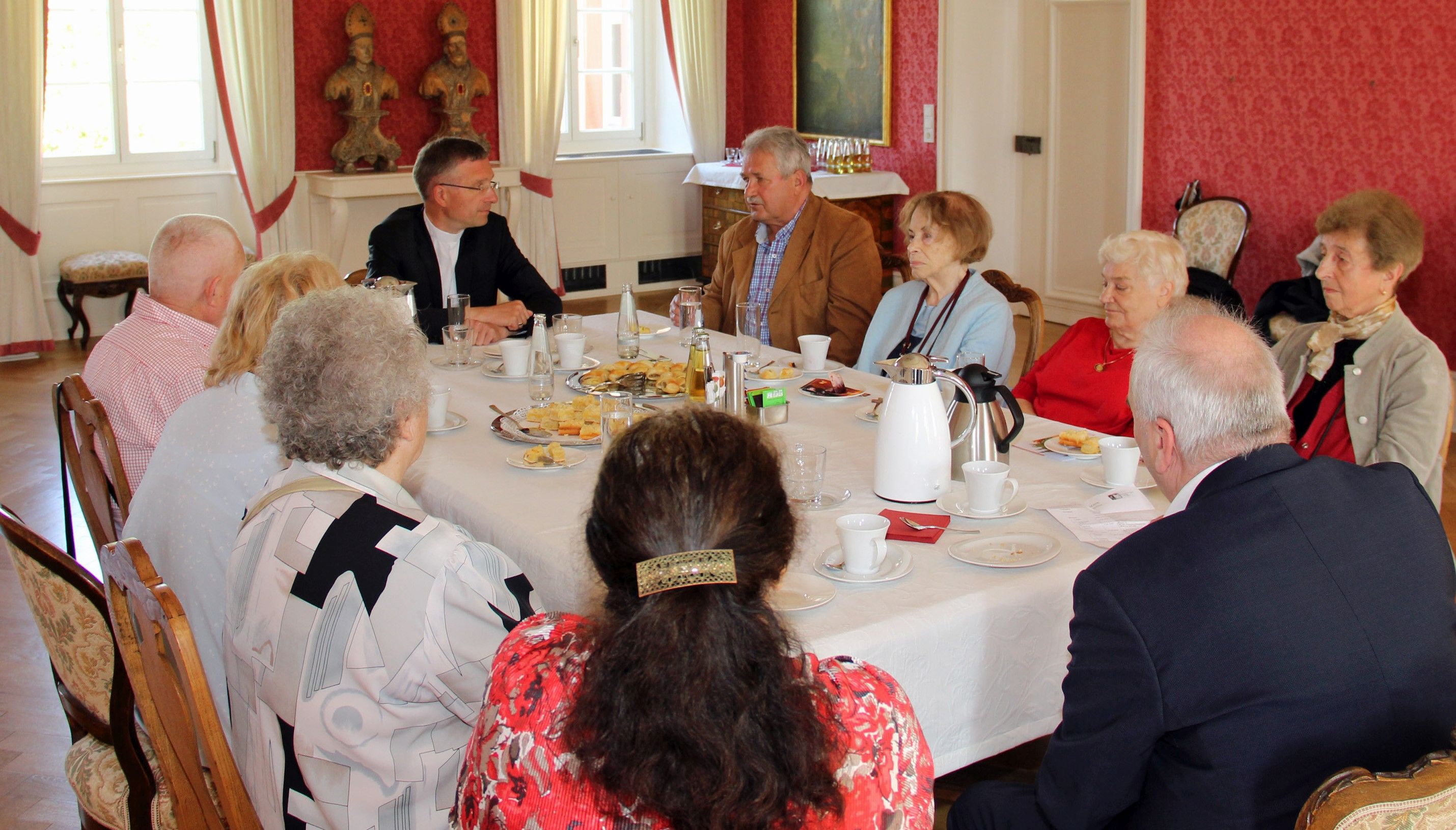 Gruppe mit Bischof beim Kaffeetrinken